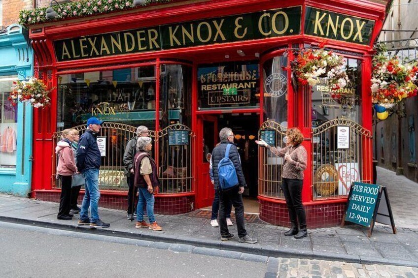 A red pub named Alexander Knox & Co. with a sign indicating it serves pub food daily from 12-9pm. 4