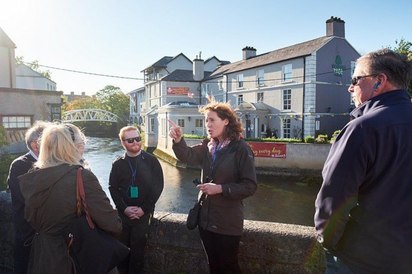 A group of people standing by a canal with buildings in the background. 3