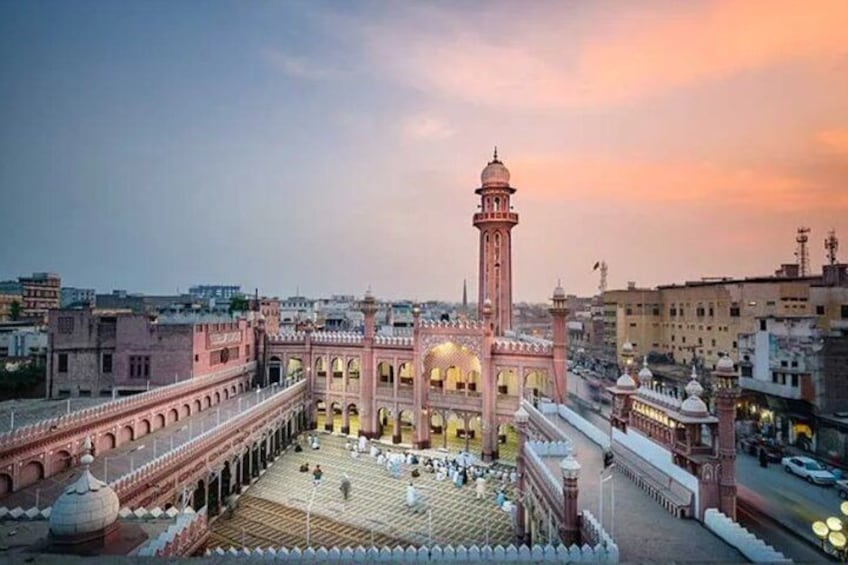 Una mezquita con un minarete alto, paseos con arcos y un amplio patio. 1