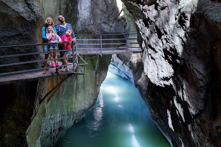 Una familia sobre un puente, cruzando un río en un cañón rocoso. 3