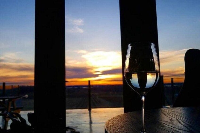 A sunset with a glass of wine on a table. 3