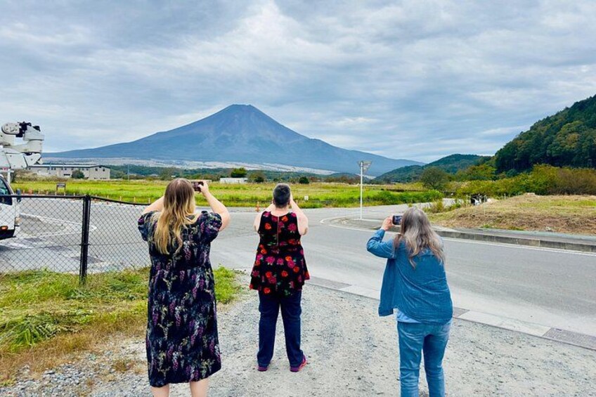 Tres personas fotografiando un volcán desde la carretera. 2