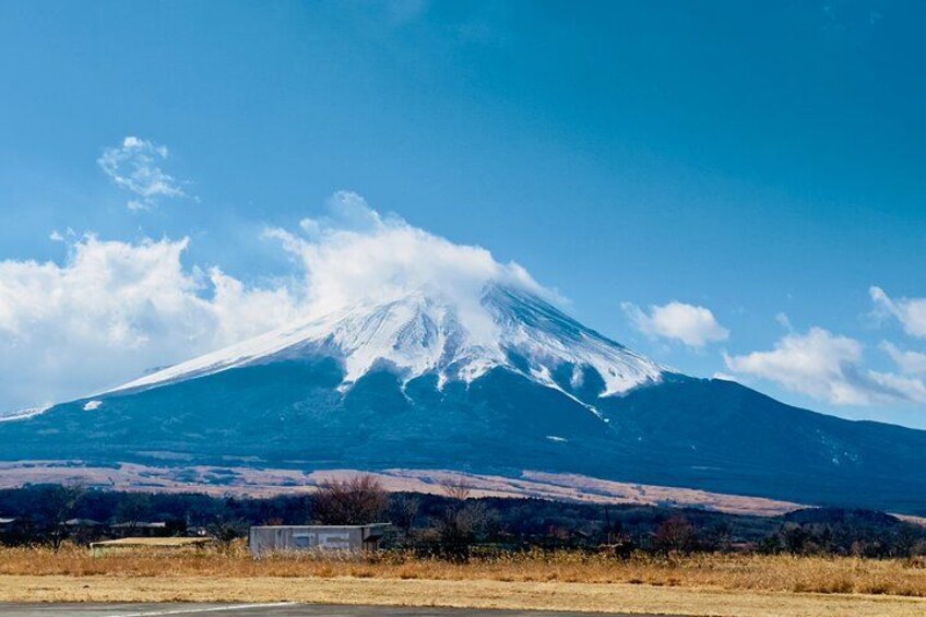 A snow-capped mountain, a clear sky, and a road in the foreground. 3