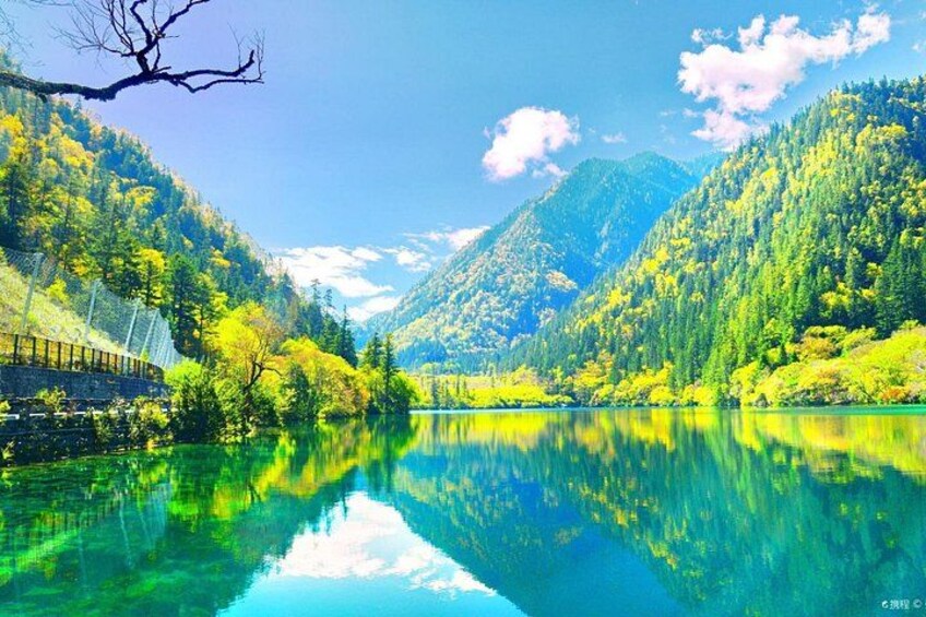 A mountain lake with clear reflections, surrounded by forested hills. 1