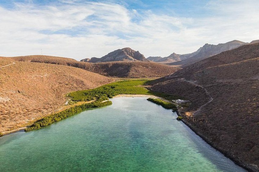 Une rivière sinueuse qui traverse un paysage montagneux, avec des eaux claires et une végétation luxuriante sur ses rives. 4