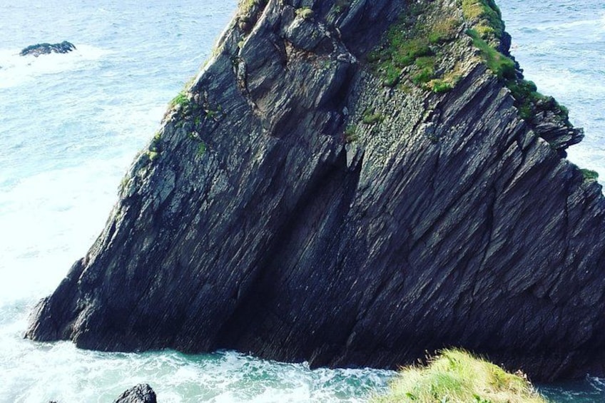 Un acantilado escarpado con olas rompiendo contra él. 1