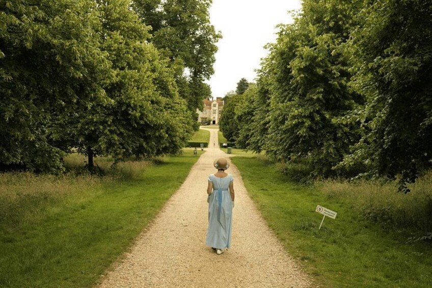 Un chemin de gravier bordé d’arbres mène à un bâtiment situé au loin. 5