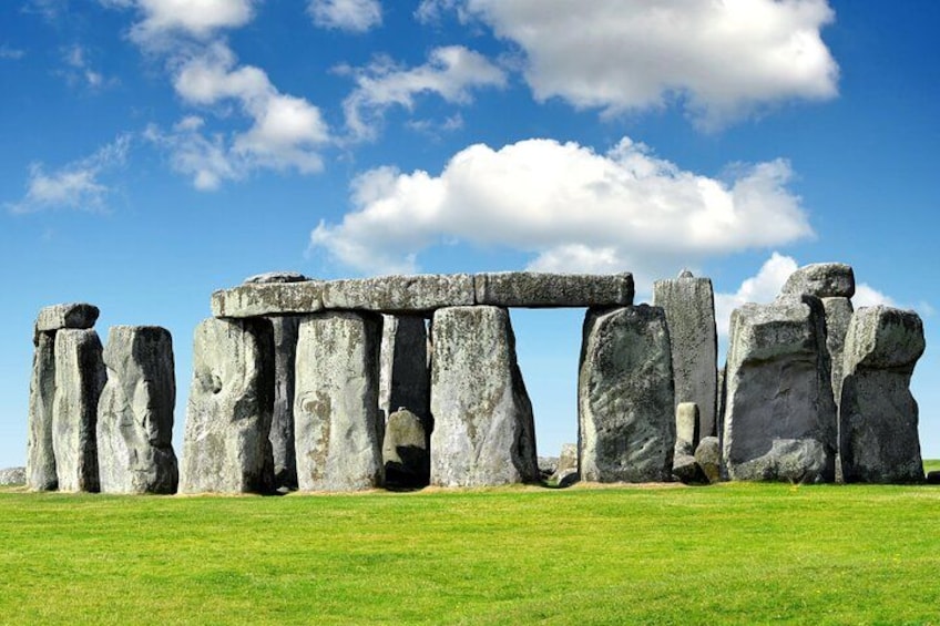Stonehenge erguido en un campo cubierto de hierba bajo un cielo azul con nubes. 3