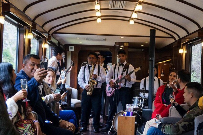 A group of people enjoying a live music performance inside a train car. 3