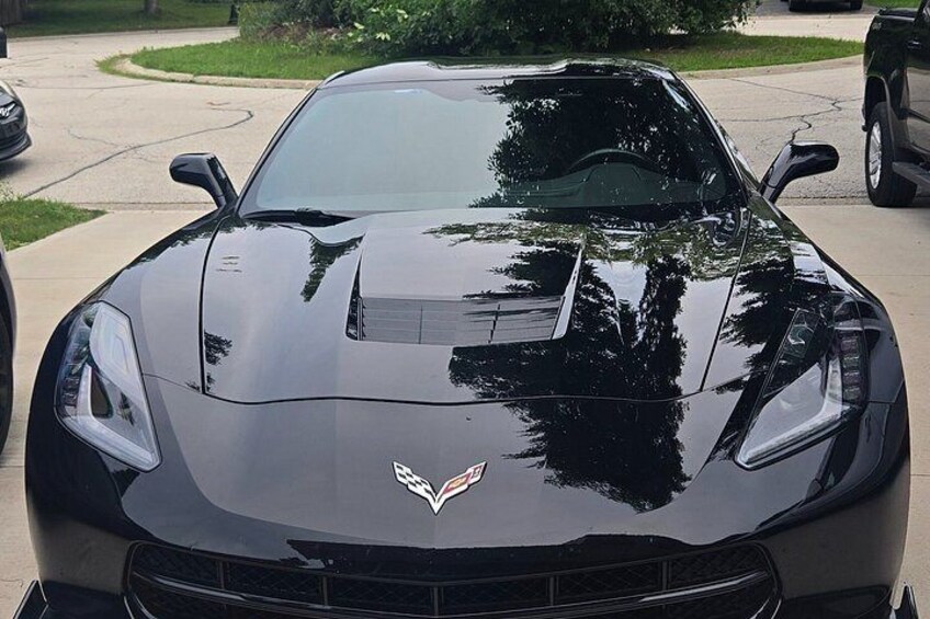 A black sports car parked on a driveway. 5
