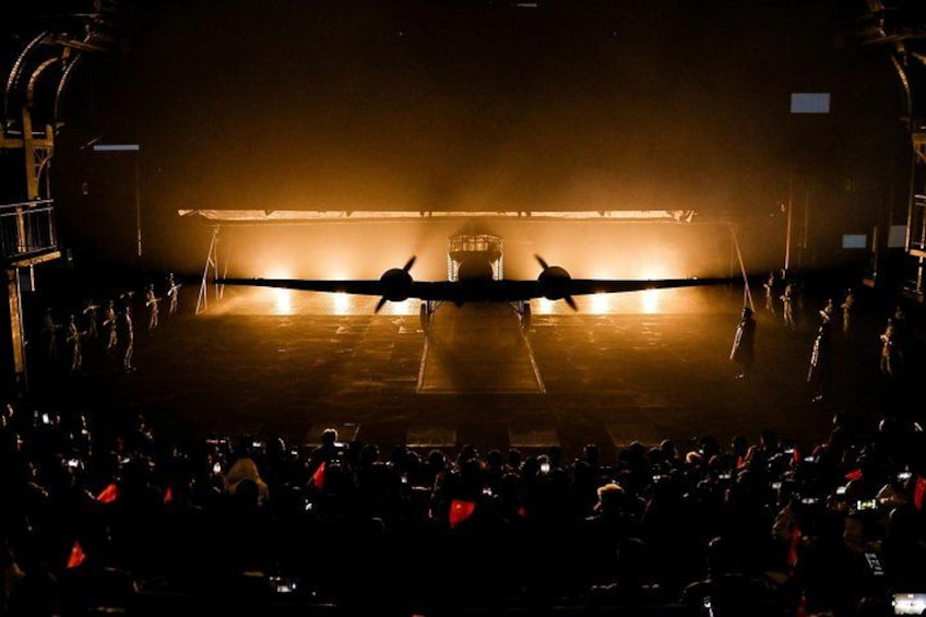 A large aircraft on a runway with a crowd of people watching. 5