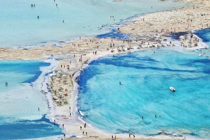 A beach with people swimming and sunbathing. 1