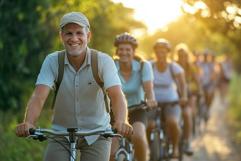 A group of cyclists on a trail with greenery in the background. 1