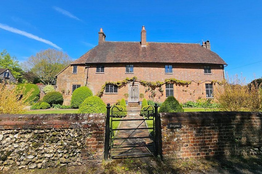 Une maison traditionnelle en briques, avec un mur en pierre et un portail. 2