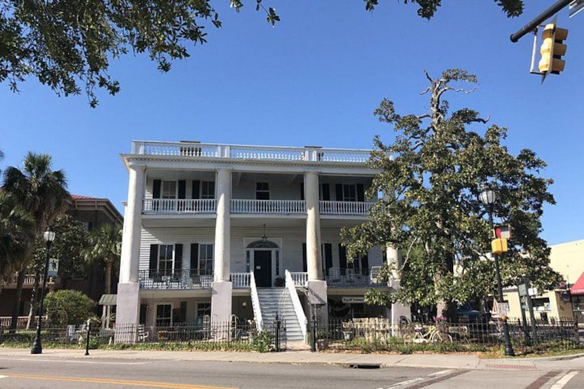 A two-story building with a balcony, a staircase, and a fence. 3