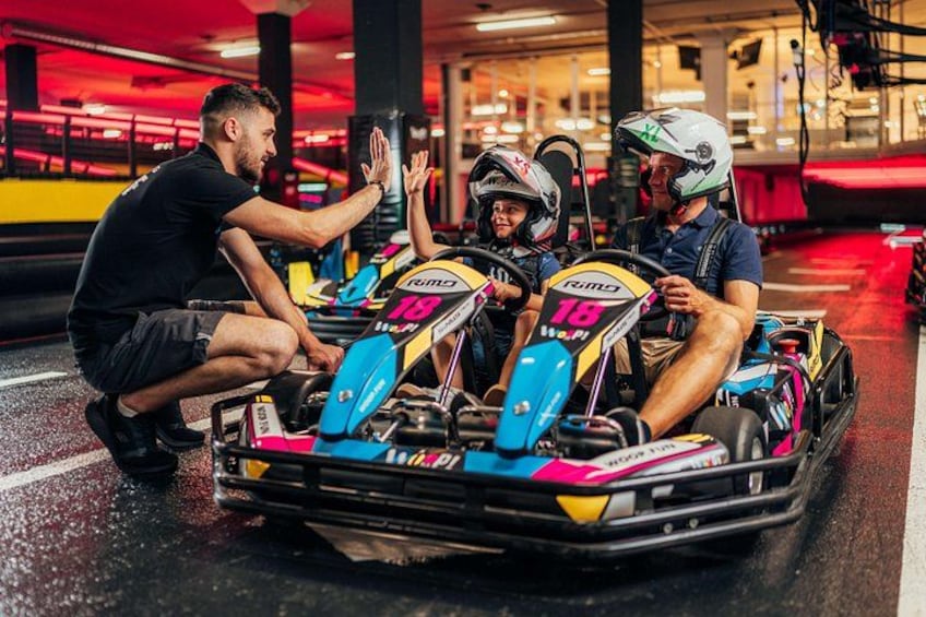 A go-kart track with go-karts and drivers. 4