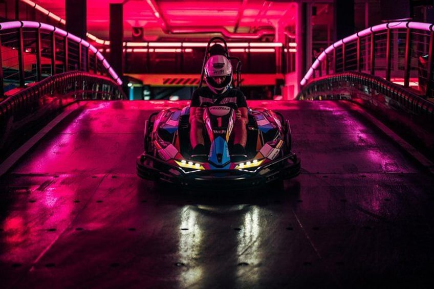 A go-kart on a wet track with neon lights. 2