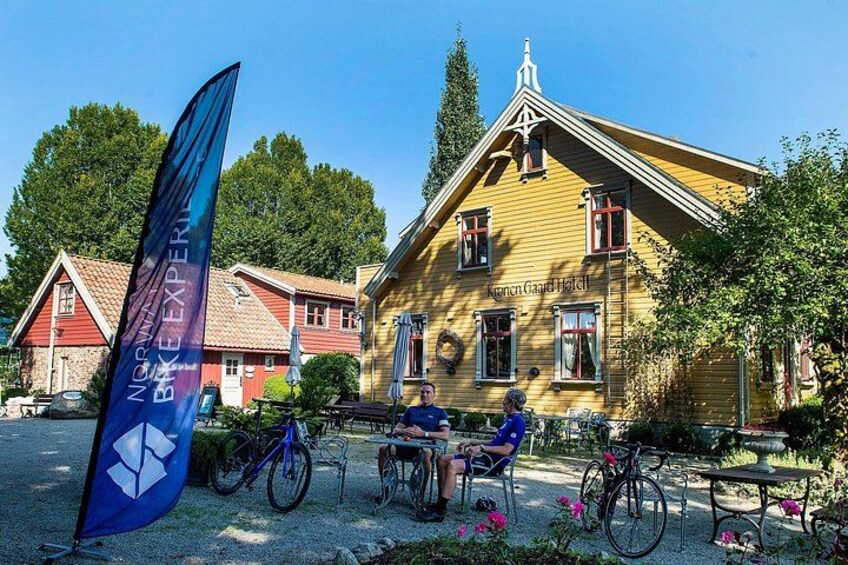 En gul bygning med rødt tag, blåt flag og cykler. 2