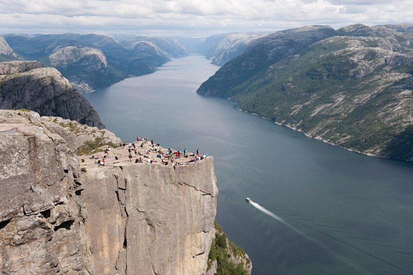 En stejl klippe med folk, der kigger ud over en fjord. 5