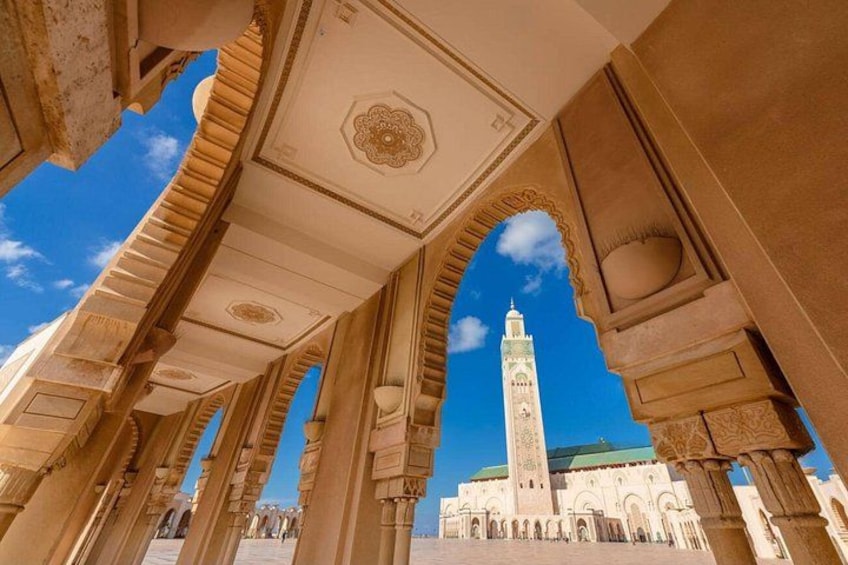 An architectural archway with intricate carvings and a clear blue sky. 1