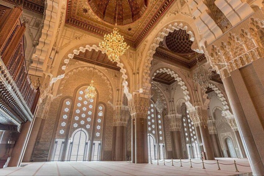 A grand interior with ornate arches, intricate tile work, and a large chandelier. 3