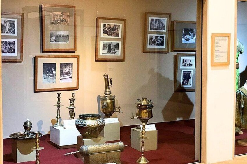 A museum exhibit with framed photographs and antique objects on display. 2