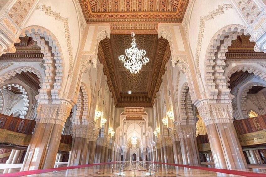 An ornate interior with arches, columns, and a chandelier. 5
