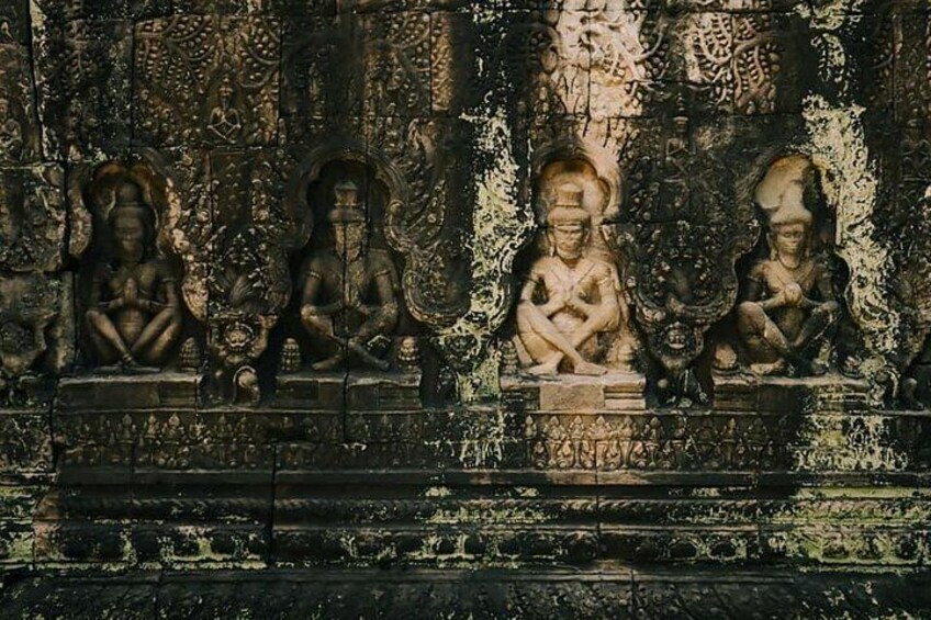 Un tallado en piedra con figuras sentadas y diseños intrincados. 4