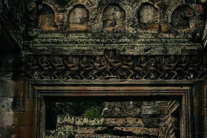 Una antigua estructura de piedra con figuras talladas y un acceso. 3