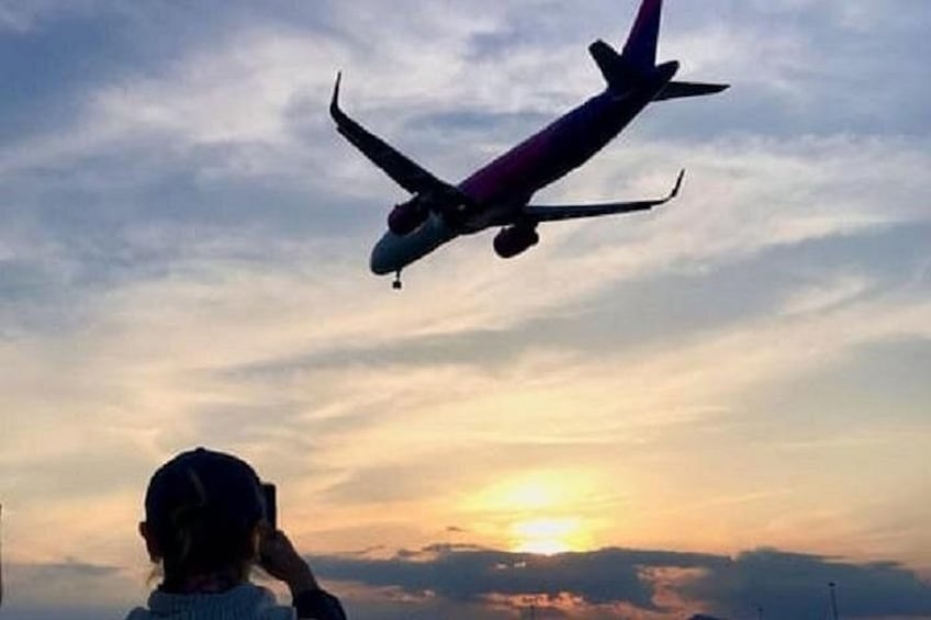 A silhouette of an airplane flying against a sunset sky. 3