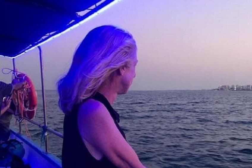 A person on a boat with a view of the sea and a distant shoreline. 2