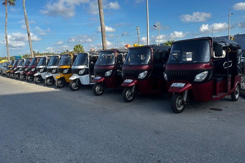 Una fila de tuk-tuks estacionados en una calle. 4