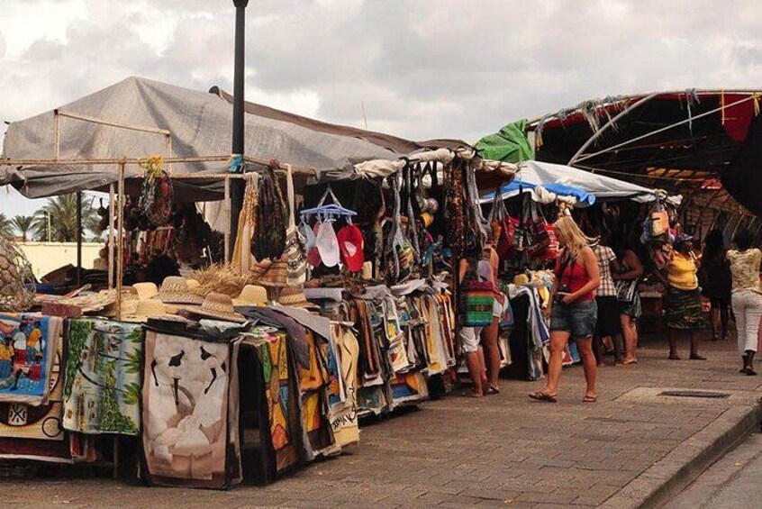 Un mercado callejero con varios puestos que venden textiles y ropa. 5