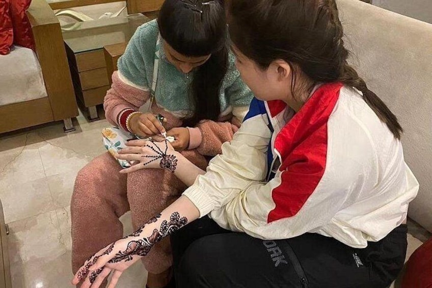 Una persona sta applicando henné sulla mano di un'altra. 5