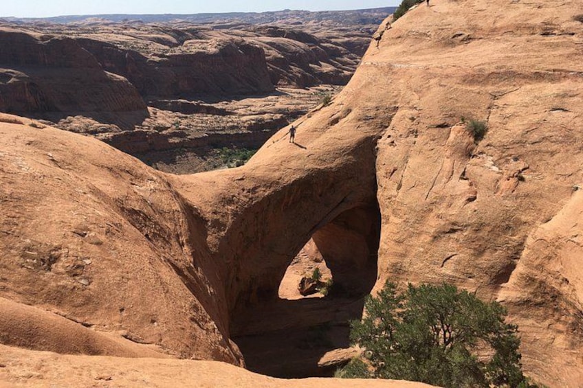 A natural rock arch formation in a desert landscape. 3