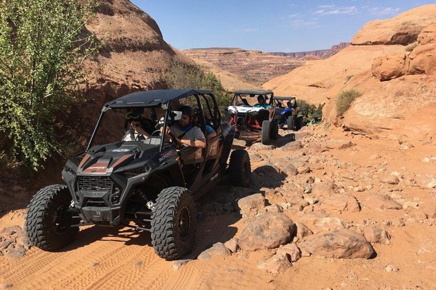 Off-road vehicles on a rocky trail in a desert landscape. 2
