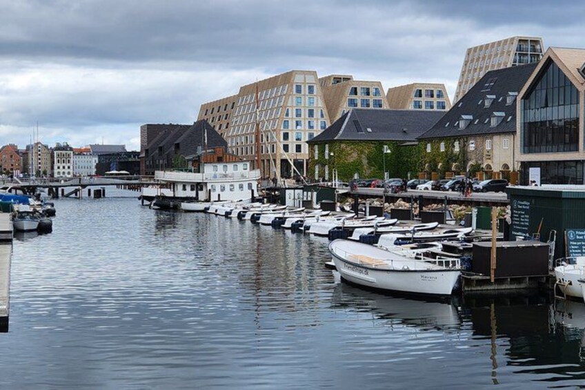 Un port de plaisance avec des bateaux amarrés, un pont et des bâtiments modernes le long de la rive. 3