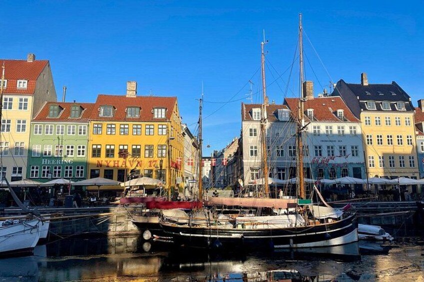 Un port avec des bâtiments aux couleurs vives et un voilier. 2