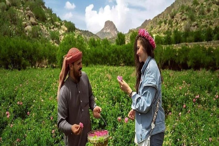 Two people in a field with flowers, one holding a basket. 1