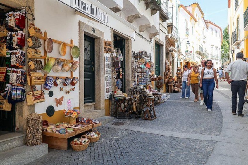 A street market with various stalls selling ceramics and pottery. 5