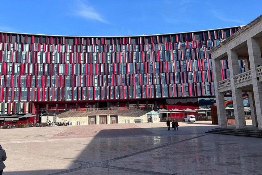 Un edificio moderno con fachada estampada, un patio central y un cielo azul despejado. 3
