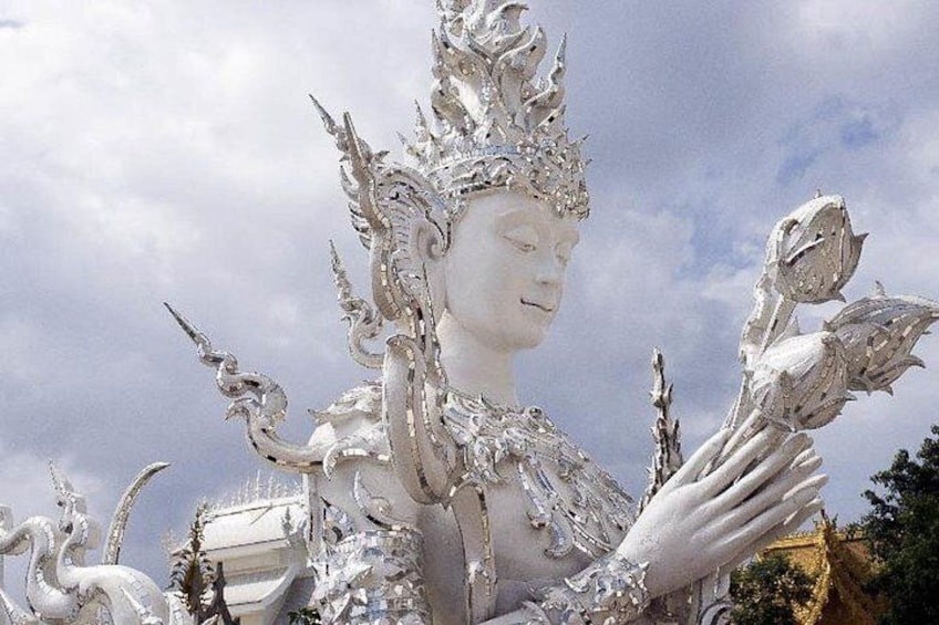 Un'imponente statua bianca con dettagli elaborati e un fiore di loto. 3