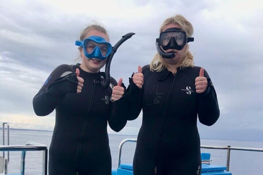 Dos personas con trajes de neopreno negros dan el visto bueno. 1