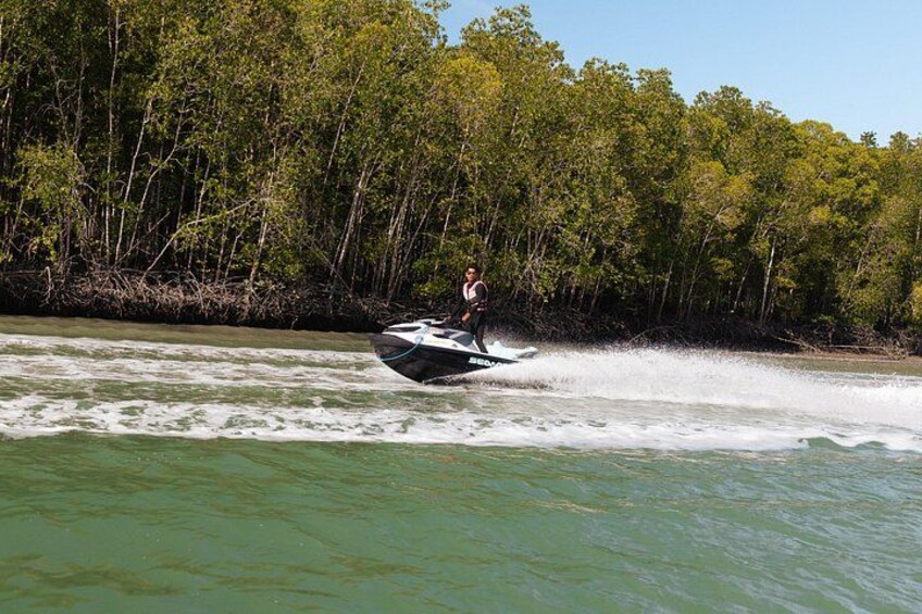 Una persona conduciendo un jet ski por un río, con árboles al fondo. 2