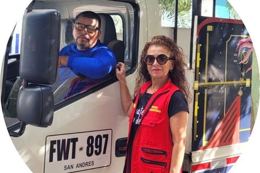 A person in a red vest standing next to a white vehicle with a license plate reading 'FWT-897' and the location 'SAN ANDRES'. 3