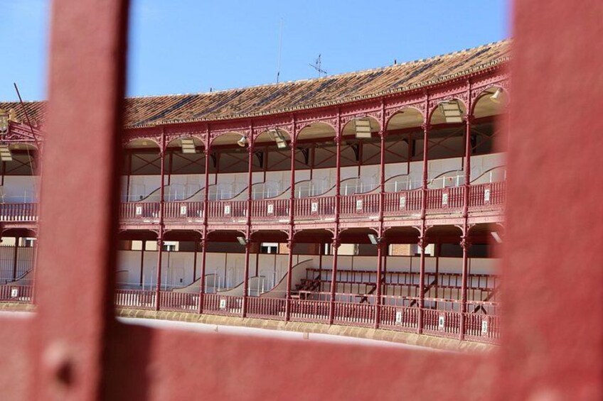 Un edificio de techo rojo con varios balcones y un cielo azul despejado. 4