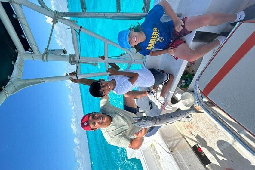 A boat with people on board, a clear blue sky, and turquoise water. 5