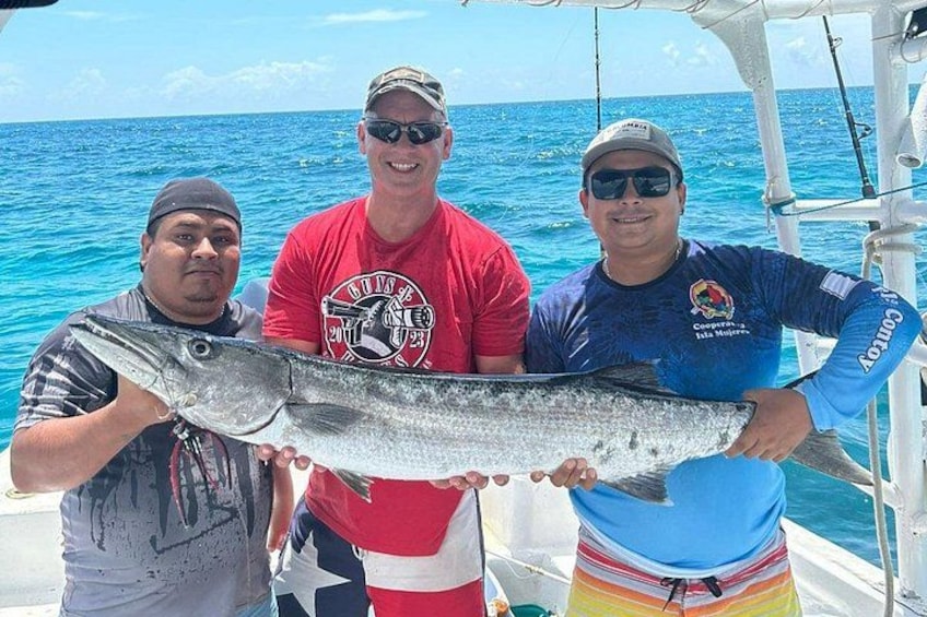 Three people on a boat holding a large fish. 2