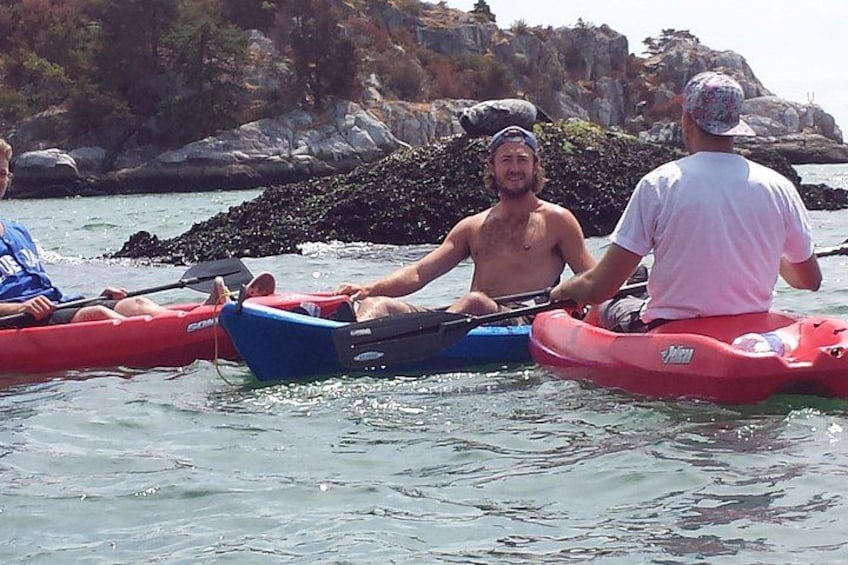 Three kayaks on calm water with rocky cliffs in the background. 5