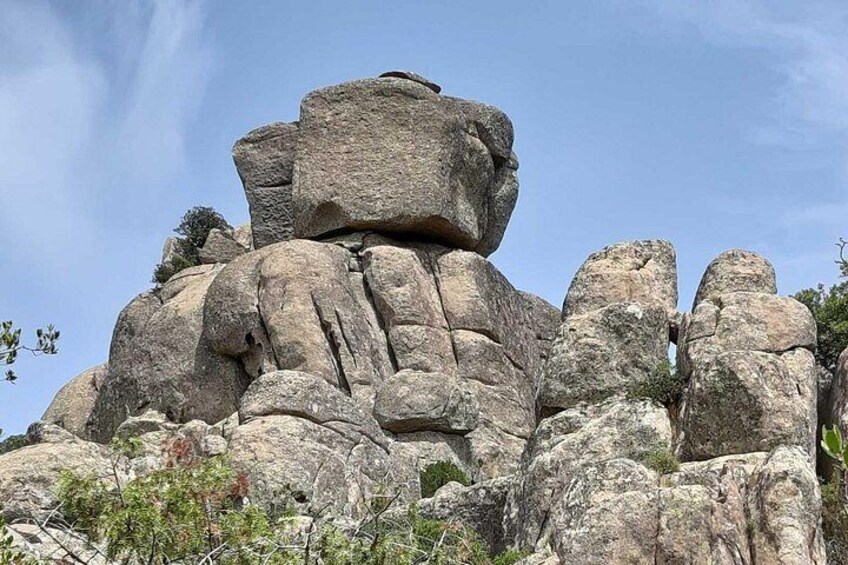 A large rock formation with multiple layers and a clear sky. 4